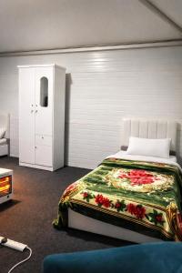 ein Schlafzimmer mit einem Bett, einer Kommode und einem Schrank in der Unterkunft خيم مبيت ملكية بالصياهد in Rumāḩ