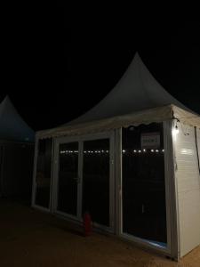 ein Zelt bei Nacht mit Lichtern in der Unterkunft خيم مبيت ملكية بالصياهد in Rumāḩ