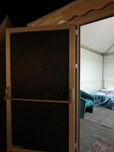eine Glasschiebetür zu einem Schlafzimmer mit einem Bett in der Unterkunft خيم مبيت ملكية بالصياهد in Rumāḩ + 1 Foto