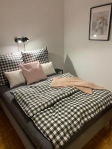 un letto con coperta e cuscini sopra di Apartament na Wybickiego a Toruń