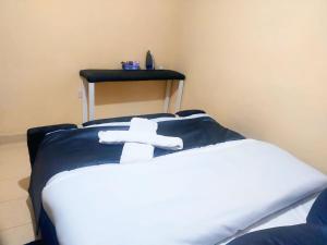 a bed with a white cross on top of it at 1 Bedroom in Section 58 behind Kunste Hotel in Nakuru +6 photos