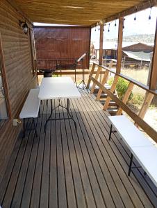 un ponte di legno con tavolo e panche. di Cabañas Campo y Mar a Los Corrales