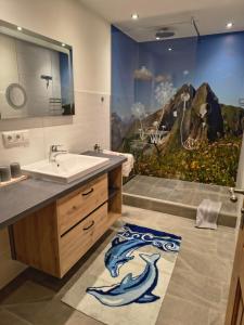 a bathroom with a sink and a painting on the wall at Gästehaus Finkel in Maderhalm +39 photos