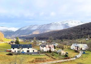un piccolo villaggio con montagne innevate sullo sfondo di Gîte cosy et paisible près de La Mongie a Campan