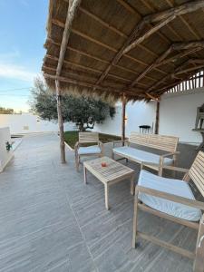 a patio with two benches and a table at Montaseur s3 in Al Maqārisah