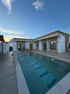 a swimming pool in front of a house at Montaseur s3 in Al Maqārisah