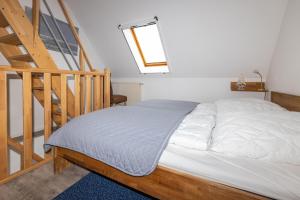 a bed in a room next to a staircase at Ferienwohnung AHOI Thiessow in Thiessow