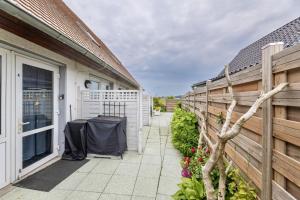 a patio with a fence and a table next to a building at Ferienwohnung AHOI Thiessow in Thiessow