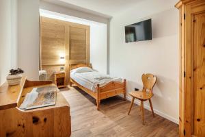 una camera da letto con un letto, una scrivania e una sedia di Nord Hotel a Cortina dʼAmpezzo