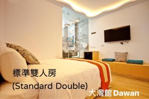 a hotel room with a bed and a tv at Kenting Dawan Homestay in Kenting +11 photos