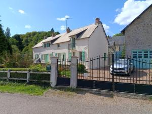 a fence in front of a house with a car at La Picherotte in Anost