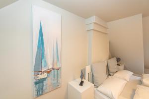 ein Schlafzimmer mit einem Gemälde eines Schiffes an der Wand in der Unterkunft Syltweh in Munkmarsch