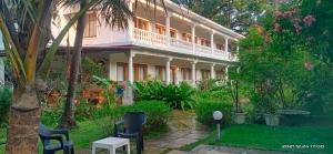 een groot wit gebouw met stoelen in de tuin bij Morjim Plaza in Morjim