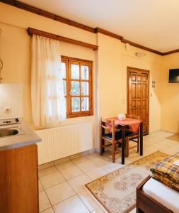 una cucina con tavolo, finestra e lavandino di Studios ΕΥΤΥΧΙΑ-6 a Kalavrita Altre 24 foto