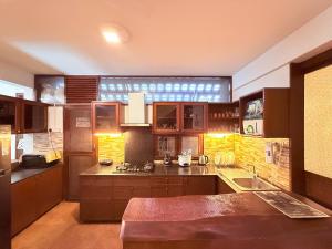 een keuken met houten kasten en een groot raam bij Jugglers Rest Boho Style 4BHK Spacez Luxury Villa with Terrace Lounge in Bangalore