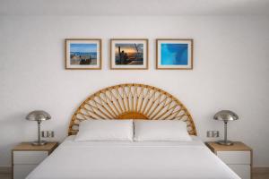 a bedroom with a white bed with three pictures on the wall at Azahara Beach in Arona +9 photos