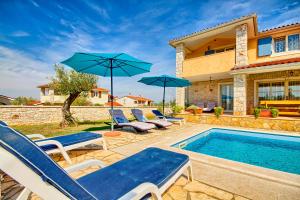 uma piscina com cadeiras e guarda-sóis ao lado de uma casa em Charming stone villa Lavanda with private pool in Pula near the beach em Gajana