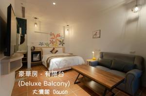 een slaapkamer met een bed, een bank en een tafel bij Kenting Dawan Homestay in Kenting