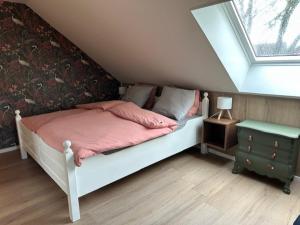 a bedroom with a bed with pink sheets and a window at 't Veurhuus in Ansen