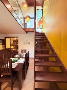 een trap naar een eetkamer met een tafel bij Jugglers Rest Boho Style 4BHK Spacez Luxury Villa with Terrace Lounge in Bangalore