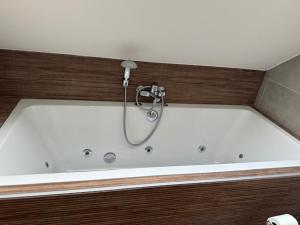 a bath tub with a shower in a bathroom at 't Veurhuus in Ansen +6 photos