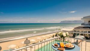 a view of the beach from the balcony of a resort at Hotel La Battigia in Alcamo Marina