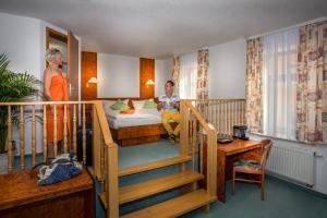 a person sitting on a bed in a hotel room at Hotel Am Markt in Ehrenfriedersdorf