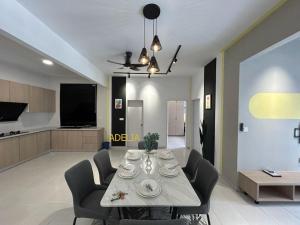 a dining room and living room with a table and chairs at Adelia SweetHome in Kajang