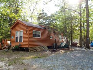 a wooden cabin in the middle of the woods at Sea Pines Park Model 1 in Swainton