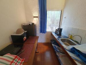 a kitchen with a counter and a sink and a window at Villa de la Plage sous les cocotiers in Saly Portudal
