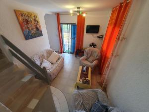 a living room with two chairs and a couch and a table at Villa de la Plage sous les cocotiers in Saly Portudal