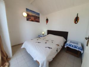 a bedroom with a bed and a table and butterflies on the wall at Villa de la Plage sous les cocotiers in Saly Portudal