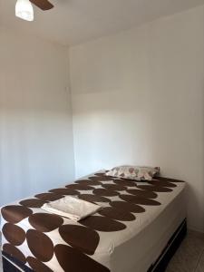 a bedroom with a large bed with brown and white sheets at Vovó Rubens Casa familiar in Piauí