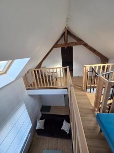 a loft with a staircase in a room at La maison de l'orée de la forêt in Hasnon