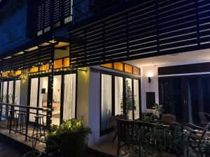 ein Haus mit einem Balkon mit einem Tisch und Stühlen in der Unterkunft WANGTA Hostel in Baan Tai