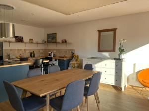 a dining room with a wooden table and chairs at La maison de l'orée de la forêt in Hasnon +27 photos