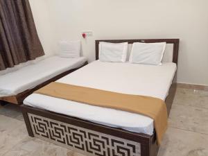two twin beds sitting next to each other in a room at Dwarka Home Stay in Dwarka +22 photos