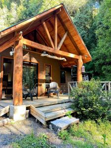 een blokhut met een veranda en een stoel op een terras bij Cabañas Alto del Bosque in Coñaripe