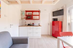 a kitchen with a red refrigerator and white cabinets at Conca d'Oro Apartments, camera 1 e 2 in Nago-Torbole