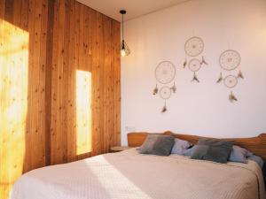 een slaapkamer met een bed met klokken aan de muur bij AlmaHouse Secluded Mountain Cabins in Alma-Ata