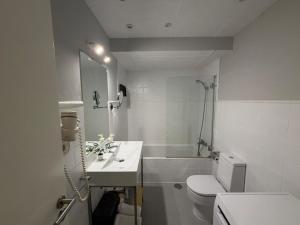 a white bathroom with a sink and a toilet at Smartmonki Sinagoga Entre la Catedral y Zocodover in Toledo +155 photos