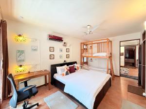 een slaapkamer met een bed en een bureau en een bureau bij Jugglers Rest Boho Style 4BHK Spacez Luxury Villa with Terrace Lounge in Bangalore
