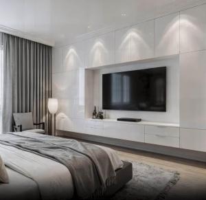 een slaapkamer met een grote tv aan een witte muur bij Victoria Residences in St Ives