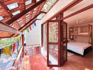 een slaapkamer met een bed en een groot raam bij Jugglers Rest Boho Style 4BHK Spacez Luxury Villa with Terrace Lounge in Bangalore +38 foto's