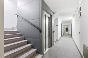 a hallway with stairs in a building with white walls at Hostdomus - Nube d'Argento in Sestriere