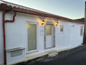 een wit huis met twee ramen en een deur bij Refúgio do Ribeirinho in Paredes de Coura