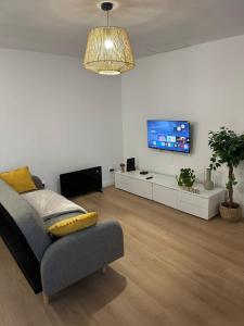 a living room with a couch and a flat screen tv at Refúgio do Ribeirinho in Paredes de Coura