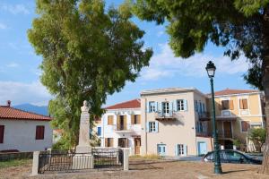 a building with a statue and a street light at Galaxidaki στην Πλατεία in Galaxidhion