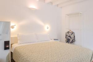 a white bedroom with a bed and a window at Galaxidaki στην Πλατεία in Galaxidhion