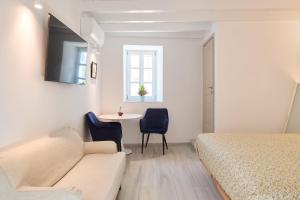 a bedroom with a bed and a table and chairs at Galaxidaki στην Πλατεία in Galaxidi